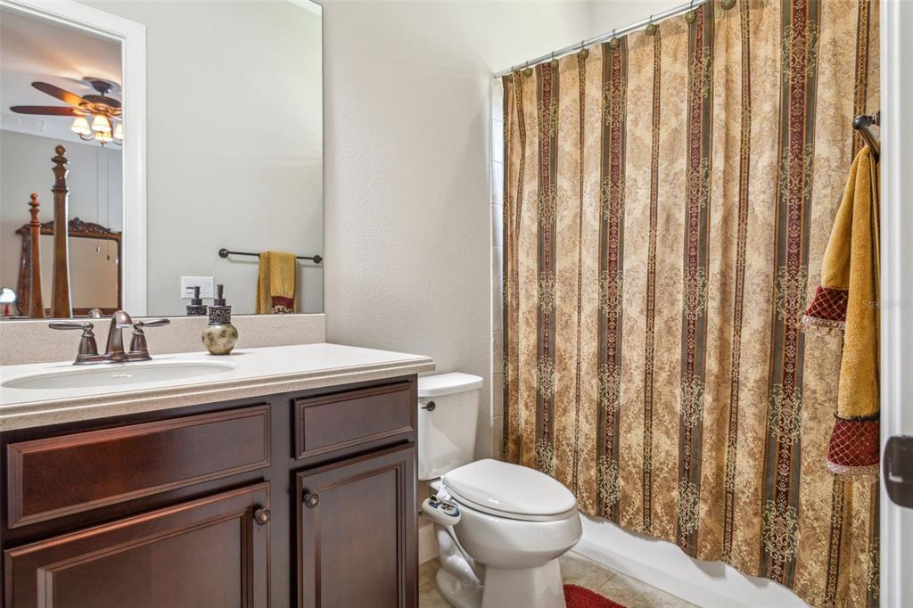 8530 Grand Alberato Road Tampa, FL 33647 - Photo 22 of 67 a bathroom with a sink a toilet and shower curtain