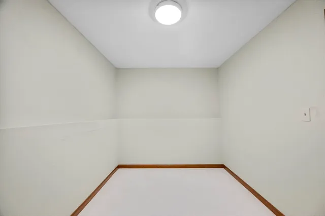 a room with a chair and white walls