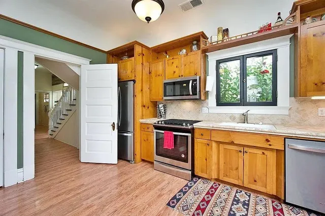 a kitchen with stainless steel appliances granite countertop a sink stove and refrigerator