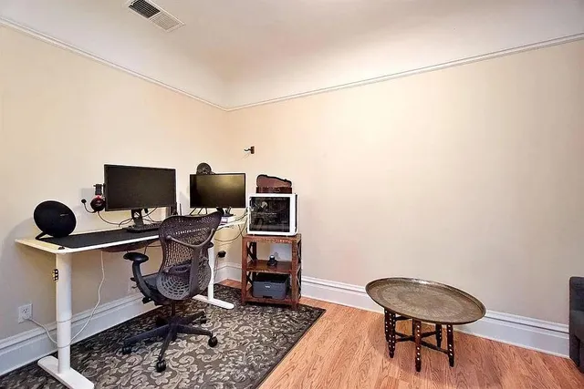 a view of a workspace with furniture and wooden floor