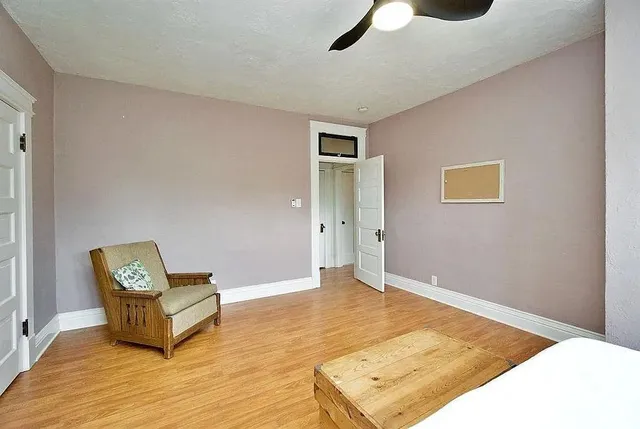 a view of a livingroom with wooden floor and a ceiling fan