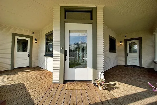 a view of a hallway with wooden floor and a glass door