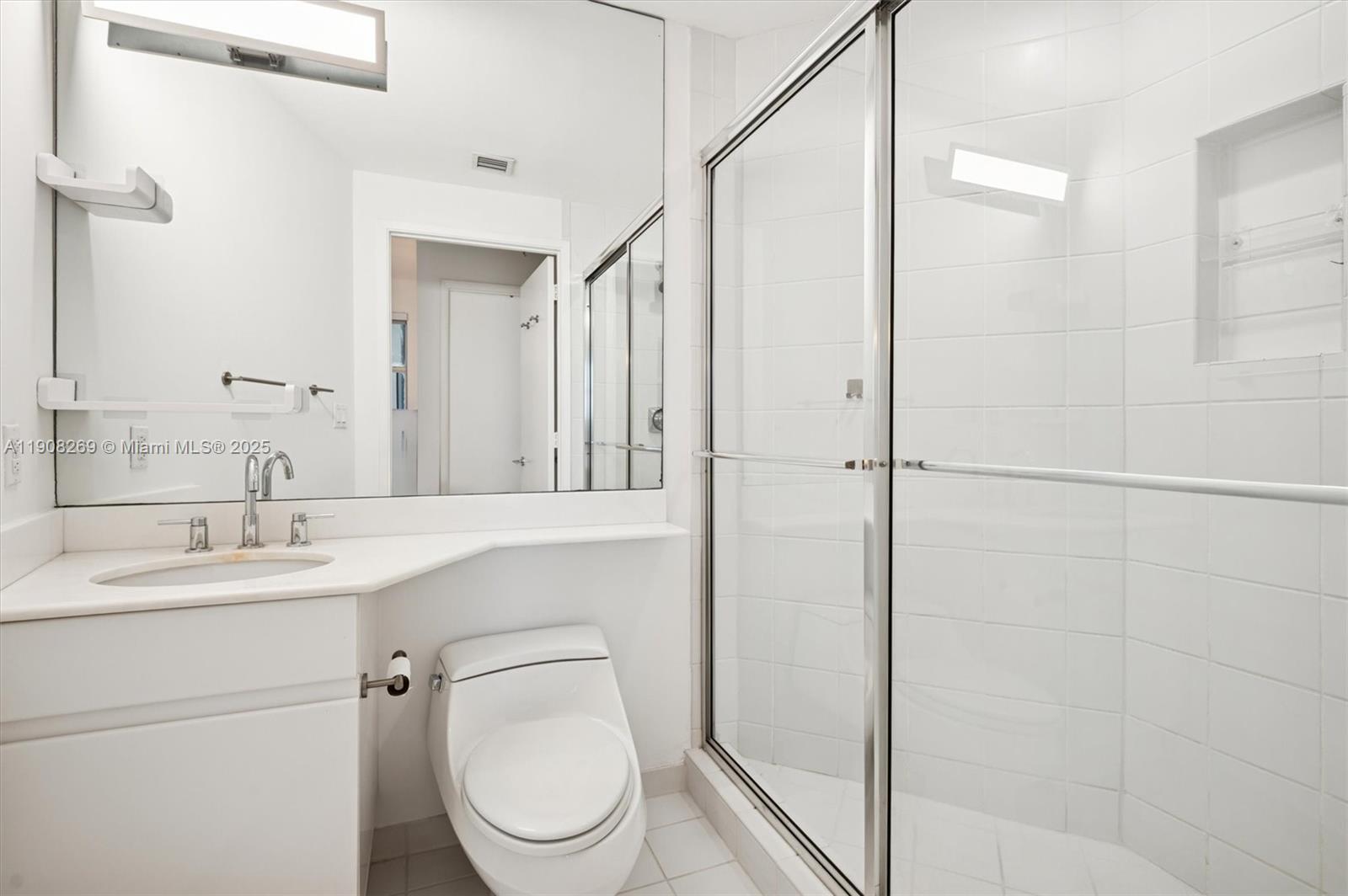 717 Crandon Boulevard, Unit 507 Key Biscayne, FL 33149 - Photo 10 of 27 a bathroom with a toilet sink shower and mirror
