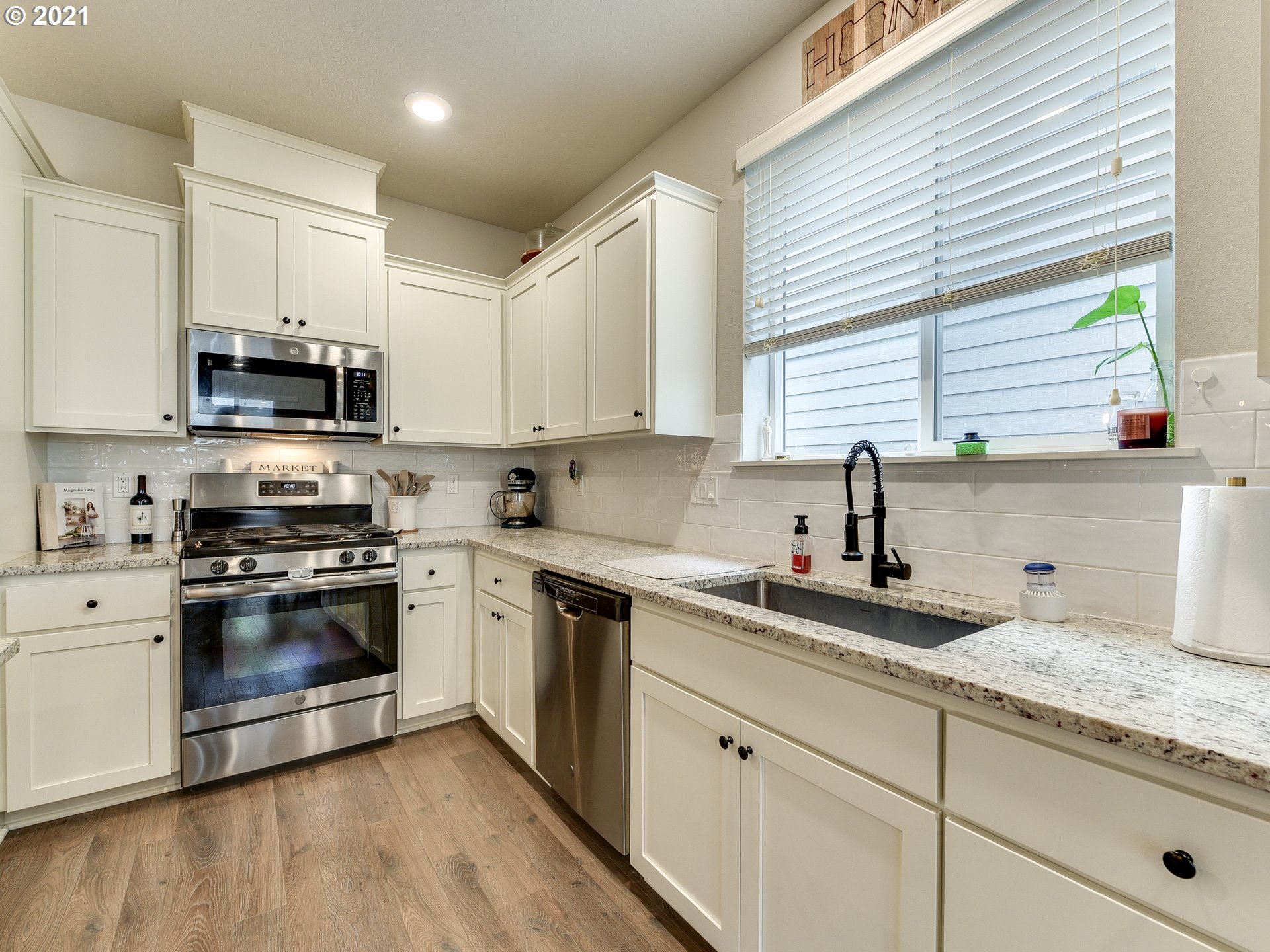 4139 Southwest Rodlun Road Gresham, OR 97080 - Photo 11 of 32 a kitchen with granite countertop white cabinets white appliances a sink and a window