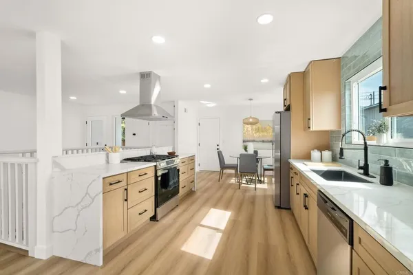 a large kitchen with stainless steel appliances a lot of counter space and a wooden floors
