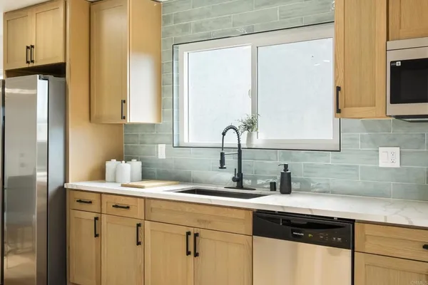 a kitchen with a sink cabinets and a window