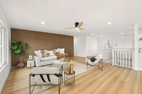 a living room with furniture and a wooden floor