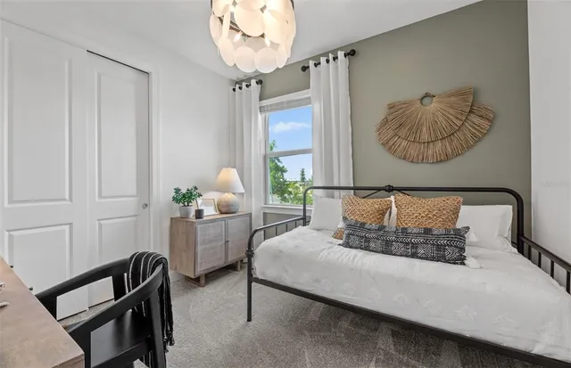 a bedroom with a bed and a chandelier