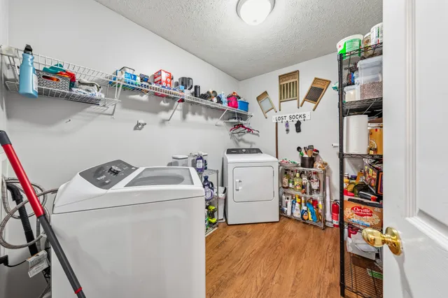 a view of a hallway with wooden floor and a living room