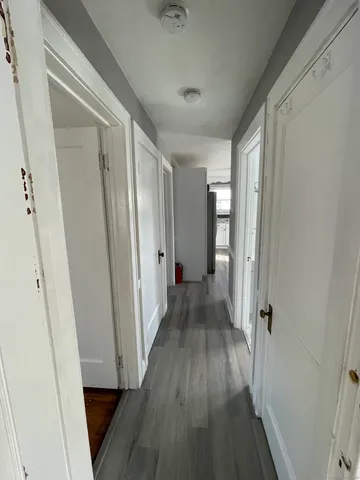 a view of a hallway with wooden floor and staircase
