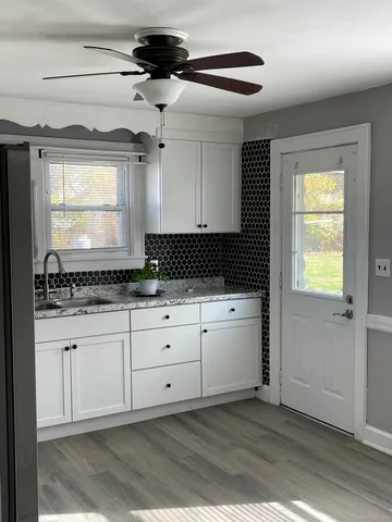 a kitchen with granite countertop cabinets stainless steel appliances and a window
