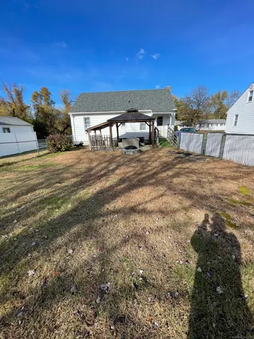 a view of a house with backyard and sitting area
