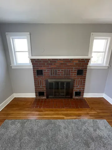 a view of a livingroom with a fireplace and window