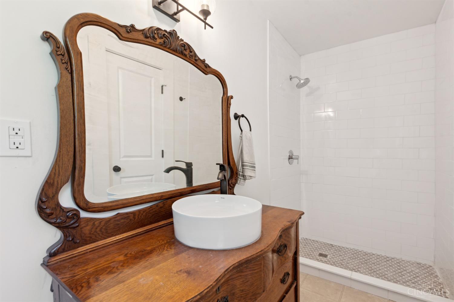 2853 Bell Road Hamilton, OH 45013 - Photo 25 of 45 1st floor full bathroom with subway tiled shower and highly sought after reclaimed dresser-turned-sink.