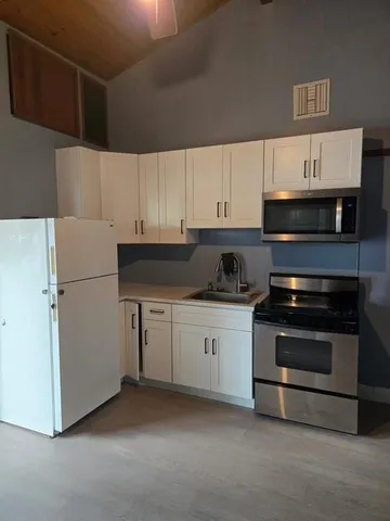 a kitchen with stainless steel appliances granite countertop a refrigerator and a stove top oven