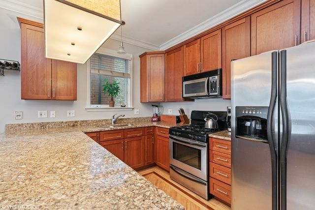 a kitchen with granite countertop a sink a counter top space stainless steel appliances and cabinets