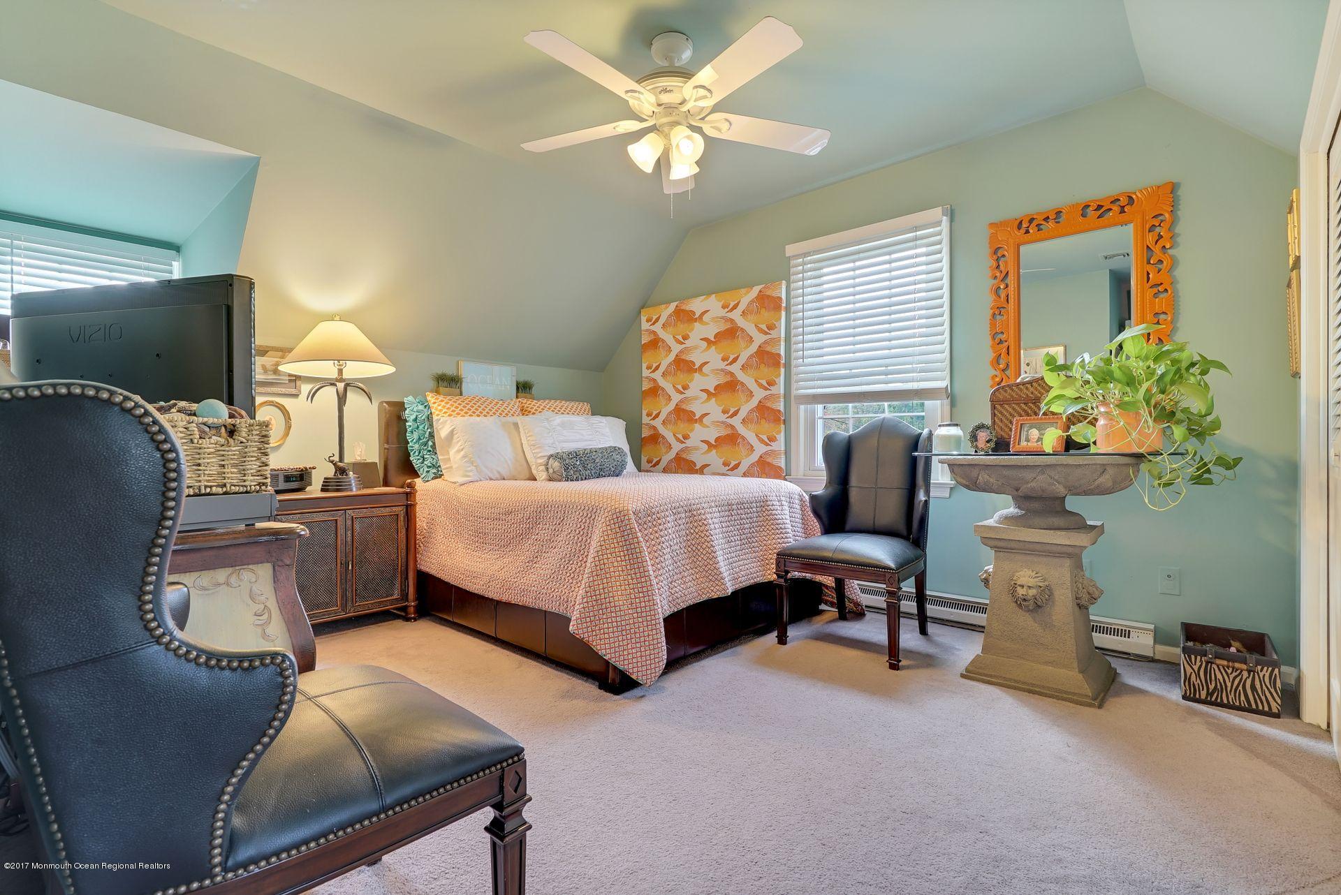 Union Avenue, Unit B Brielle, NJ 08730 - Photo 26 of 28 a bedroom with a bed and a chandelier