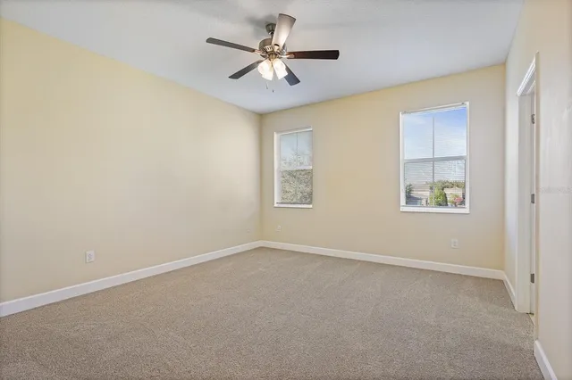an empty room with a window and a ceiling fan