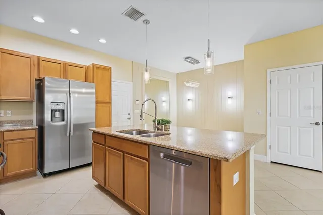 a kitchen with stainless steel appliances granite countertop a sink a refrigerator and a refrigerator