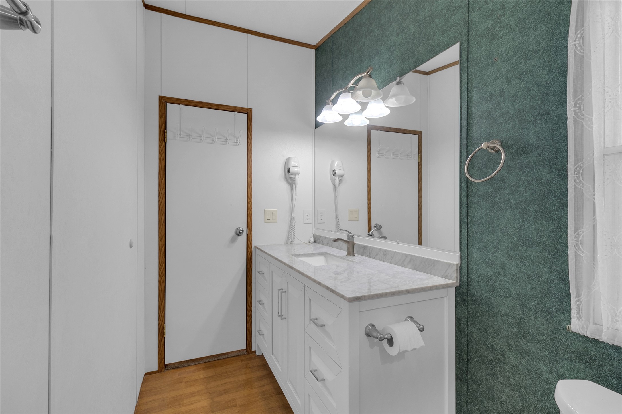 22094 Spear Road Porter, TX 77365 - Photo 25 of 45 This bathroom features a sleek design with a large mirror, elegant lighting, and a white vanity.