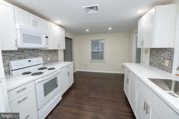 a kitchen with a stove sink and cabinets