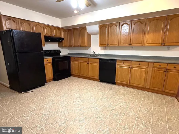 a kitchen with stainless steel appliances granite countertop a refrigerator a sink dishwasher and wooden cabinets