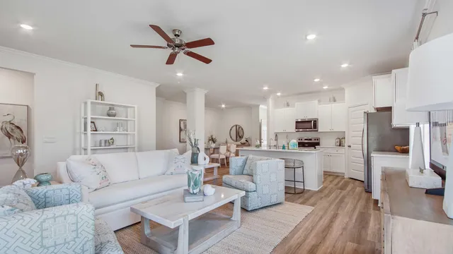 a living room with stainless steel appliances furniture and a view of kitchen