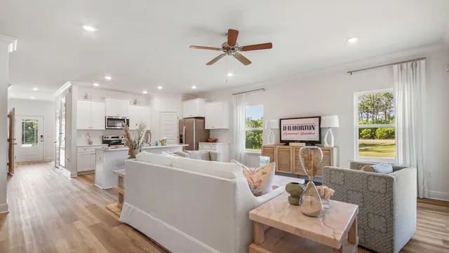 a living room with furniture kitchen view and a large window