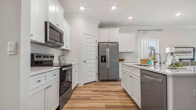 a kitchen with stainless steel appliances a sink stove refrigerator and cabinets