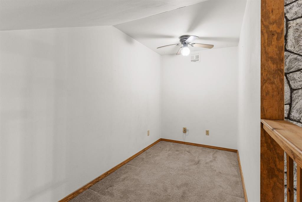 13315 Highway 281 Scotland, TX 76379 - Photo 30 of 40 Cozy nook/ playroom with carpet, ceiling fan with integrated lighting and wood railing overlook
