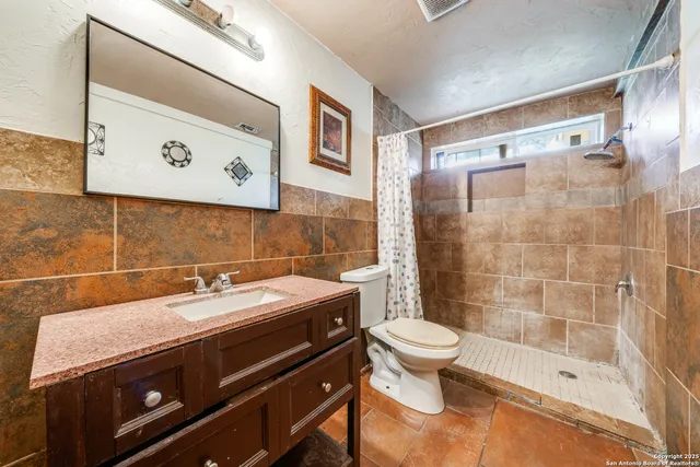 a bathroom with a sink a toilet and shower