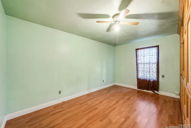 wooden floor in an empty room with a window