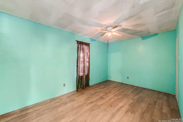 an empty room with a fan and a fan