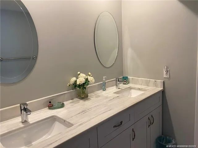 a bathroom with a double vanity sink and a mirror
