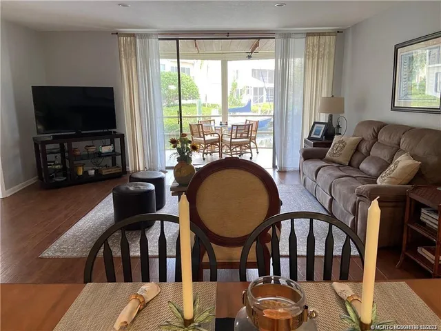 a living room with furniture a flat screen tv and a floor to ceiling window