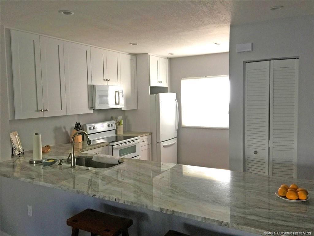 3901 Southeast St Lucie Boulevard, Unit D29 Stuart, FL 34997 - Photo 7 of 26 a kitchen with granite countertop a refrigerator and a sink