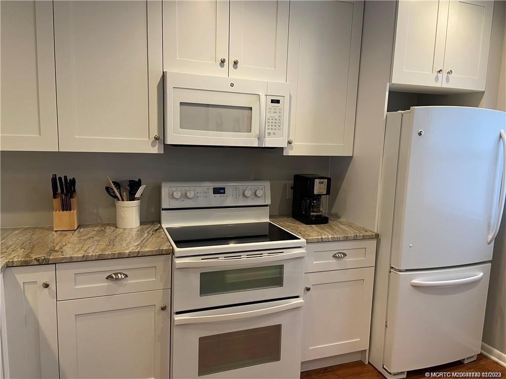 3901 Southeast St Lucie Boulevard, Unit D29 Stuart, FL 34997 - Photo 8 of 26 a kitchen with white cabinets and white appliances
