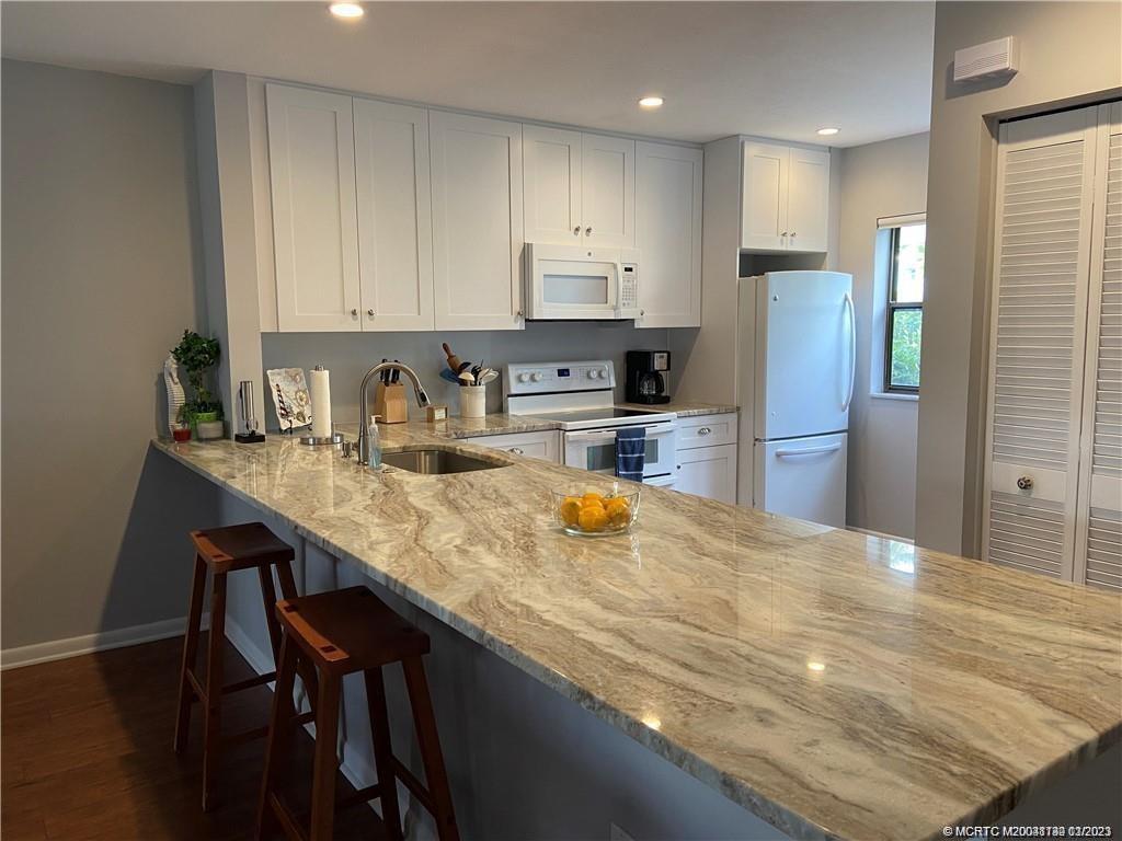 3901 Southeast St Lucie Boulevard, Unit D29 Stuart, FL 34997 - Photo 9 of 26 a kitchen with refrigerator and cabinets