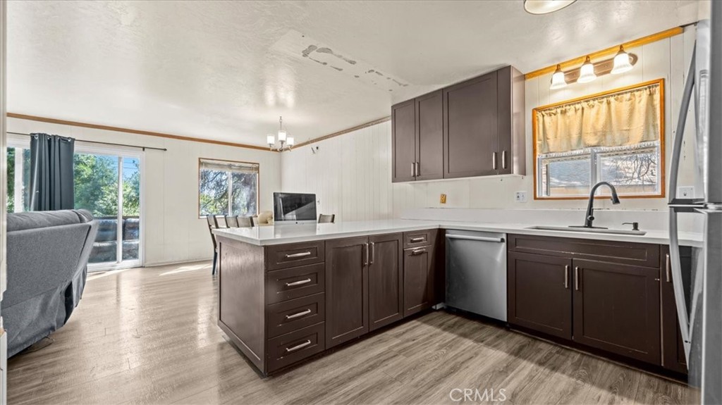 31347 Circle View Drive Running Springs, CA 92382 - Photo 12 of 48 a kitchen with stainless steel appliances granite countertop a sink dishwasher a refrigerator and cabinets with wooden floor