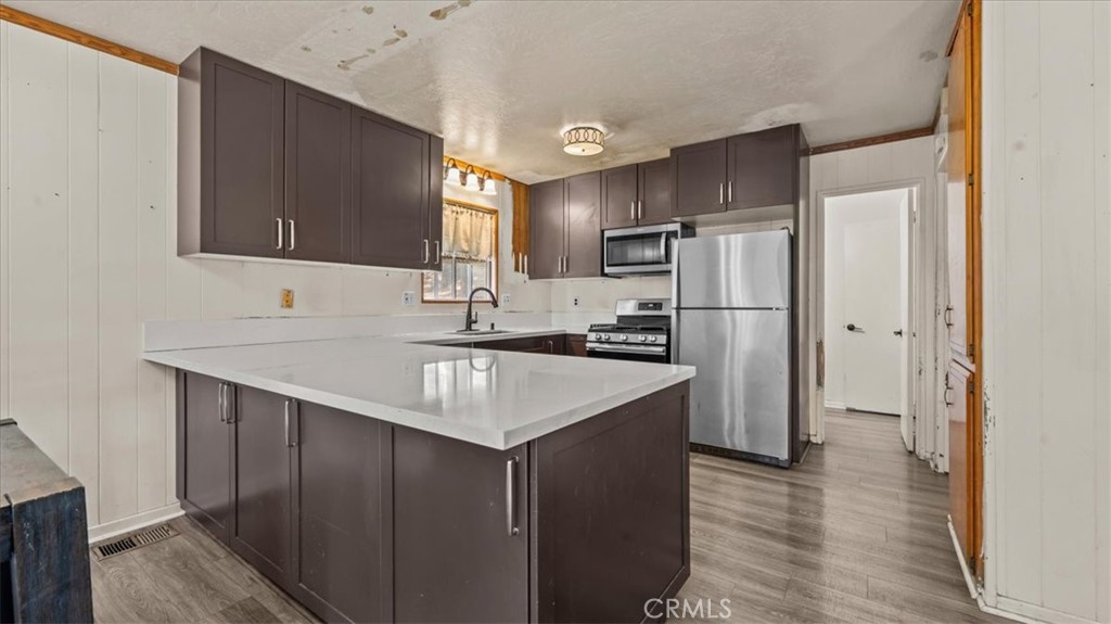 31347 Circle View Drive Running Springs, CA 92382 - Photo 15 of 48 a kitchen with kitchen island a sink refrigerator and cabinets