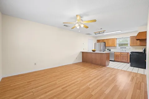 a view of a kitchen with wooden floor and windows