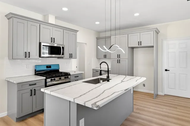 a kitchen with a sink a stove a refrigerator and a refrigerator