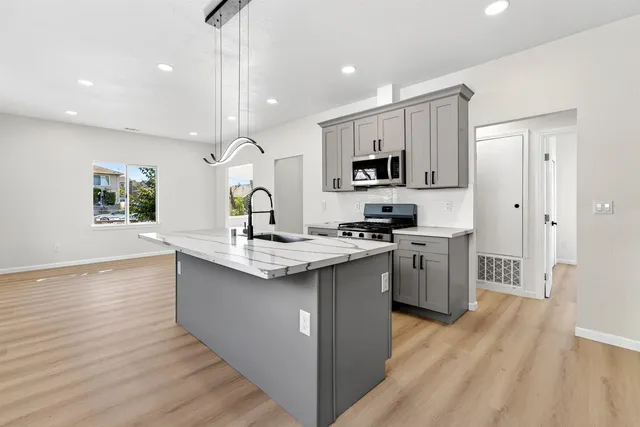 a kitchen with stainless steel appliances granite countertop a sink stove and refrigerator