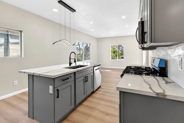 a kitchen with a sink a stove and a refrigerator