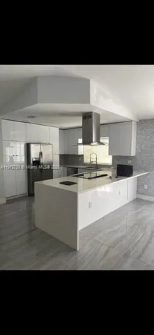 a large white kitchen with stainless steel appliances