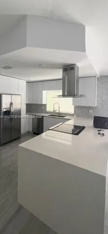 a kitchen with stainless steel appliances a refrigerator stove and white cabinets