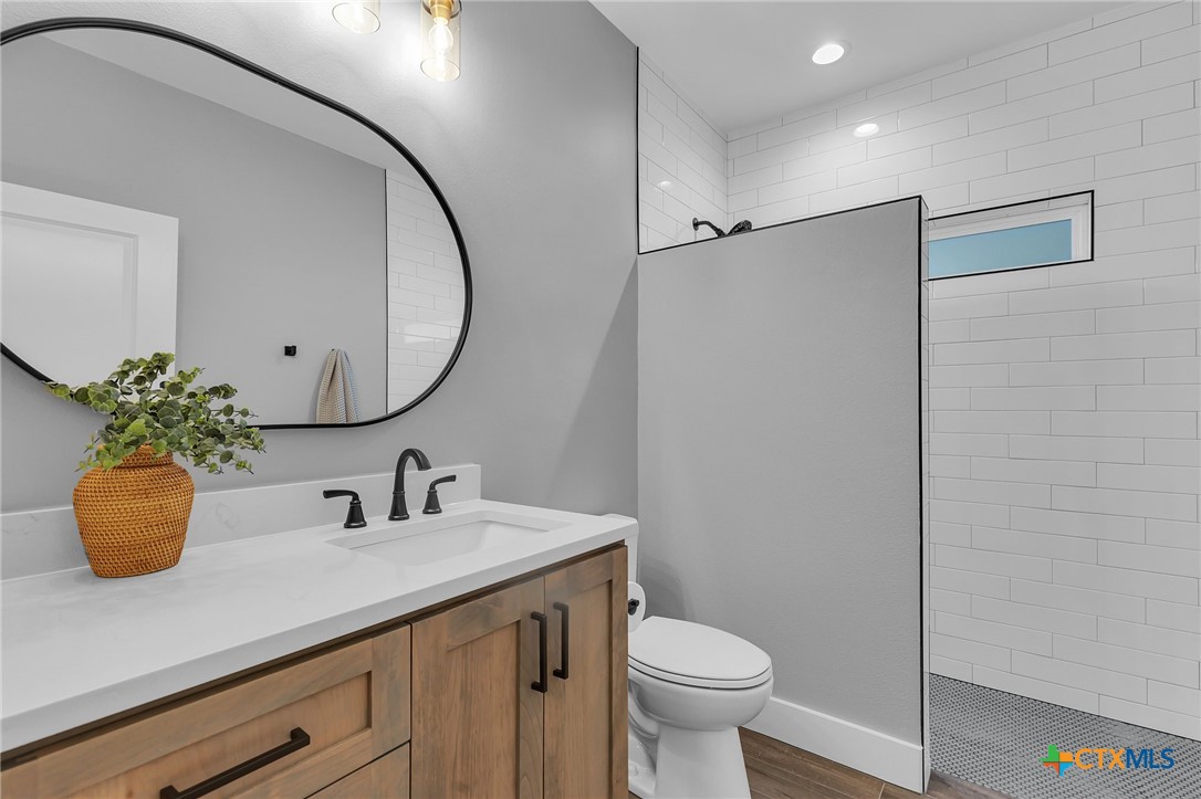 540 River Run, Unit 314 New Braunfels, TX 78132 - Photo 11 of 15 a bathroom with a sink a toilet a mirror and shower