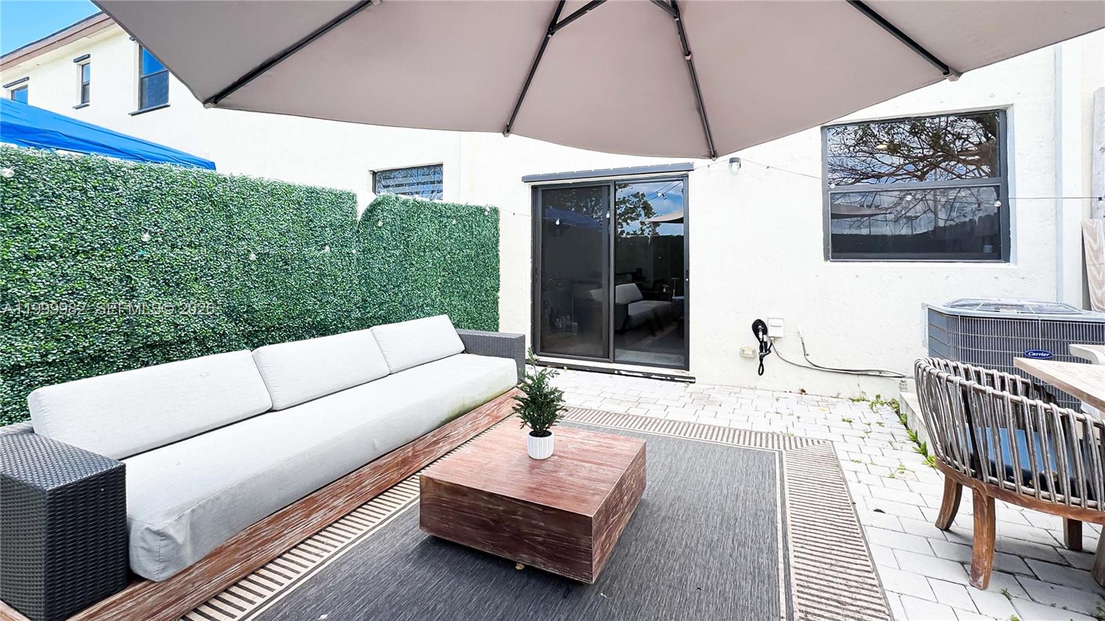 9949 Southwest 228th Terrace Miami, FL 33190 - Photo 2 of 40 a view of a patio with a table and chairs under an umbrella
