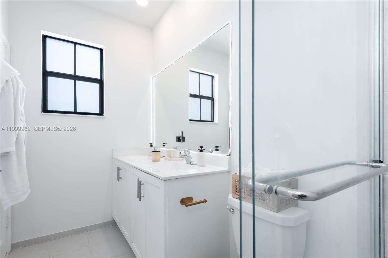 9949 Southwest 228th Terrace Miami, FL 33190 - Photo 21 of 40 a bathroom with a sink a toilet and mirror