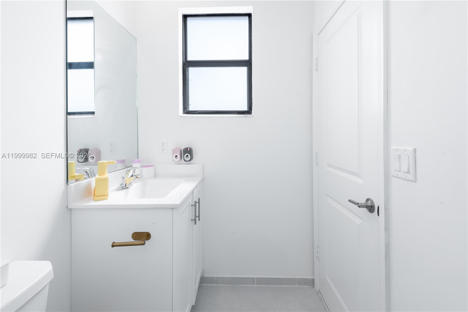 9949 Southwest 228th Terrace Miami, FL 33190 - Photo 27 of 40 a bathroom with a sink a toilet and a mirror